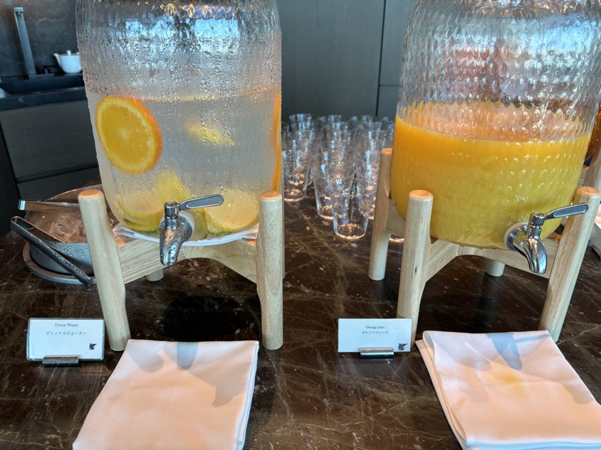 果物入りの水とオレンジジュースのドリンクディスペンサー