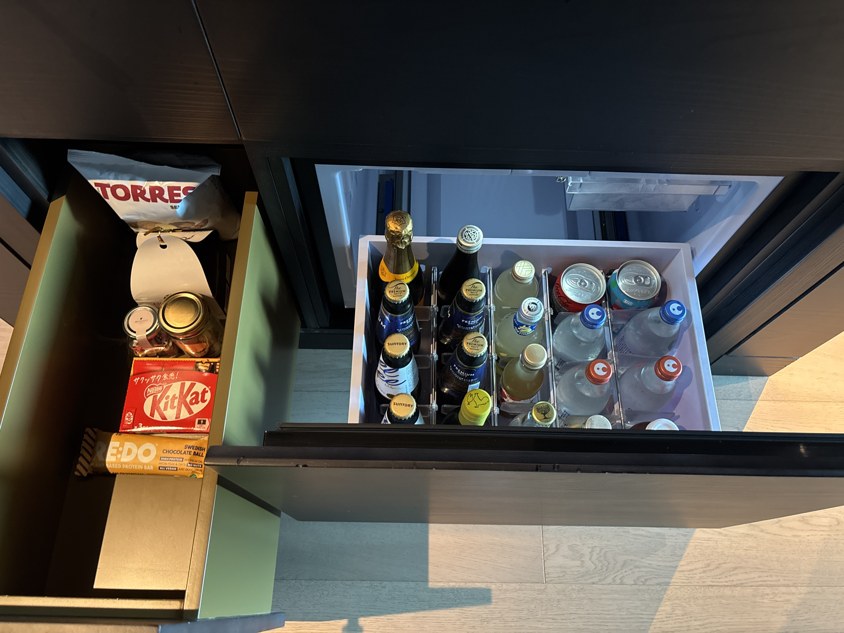 客室の冷蔵庫に並ぶビールやジュースとスナックの引き出し