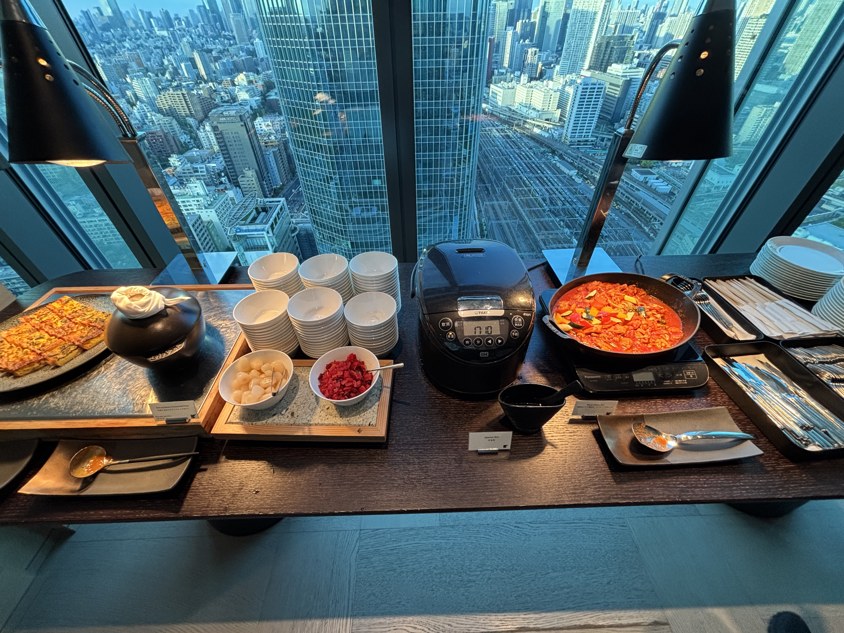 白米の炊飯器と煮込み料理が並ぶラウンジの温かい料理の台
