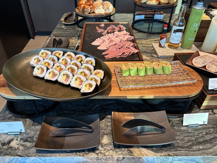太巻きとスモークサーモンのクレープロールが並ぶ冷菜の台