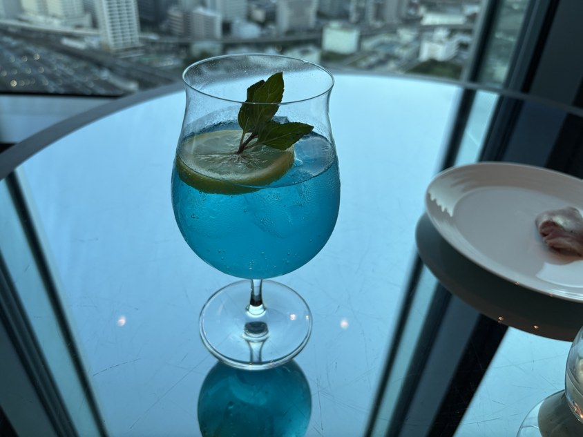 柑橘の輪切りと葉を添えた青い飲み物