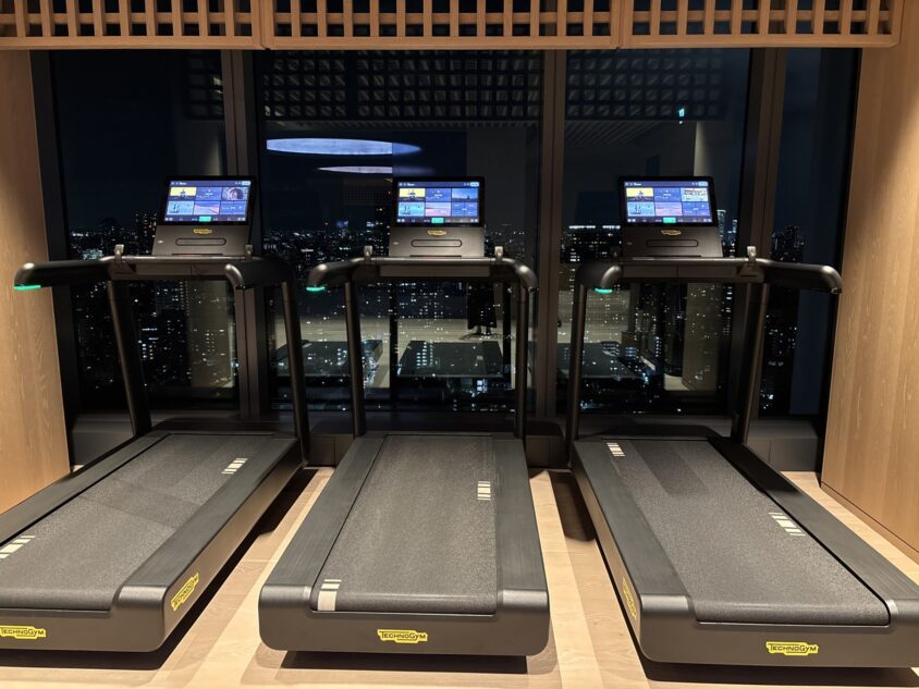 夜景に向かって並ぶフィットネスジムのランニングマシン