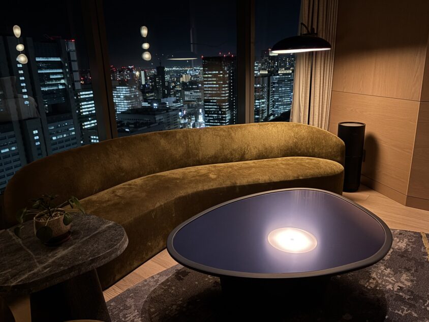 夜のジュニアスイートのソファと窓の外に見えるビルの灯り